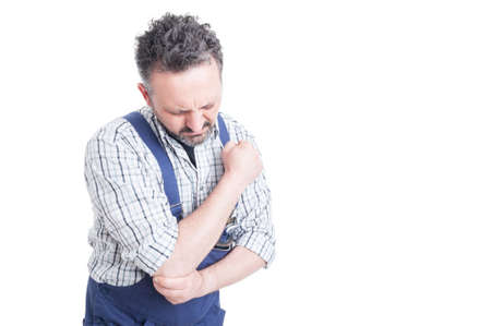 Portrait of young mechanic having pain in injured arm or elbow with advertising area isolated on white backgroundの写真素材