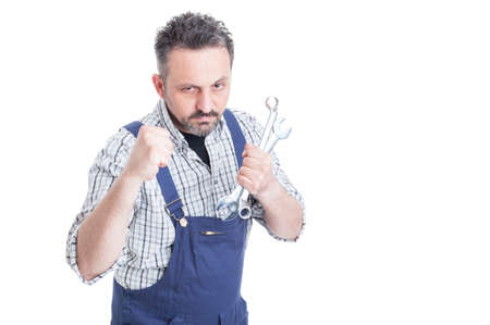 Angry young mechanic being ready for a fight showing his fists isolated on white background with copyspaceの写真素材