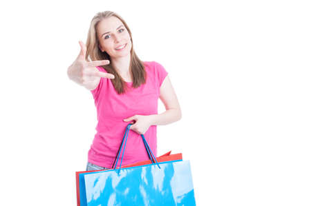 Cheerful young woman showing number three or third and carrying her shopping bags with text area isolated on whiteの写真素材