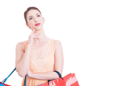 Attractive lady being thoughtful or pensive holding shopping bags isolated on white background with copy text spaceの写真素材