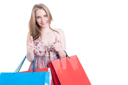 Shopping woman holding colorful bags and showing double like or thumbup gesture with copyspace area...
