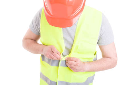 Male constructor with helmet and vest gets ready for work as safety uniform concept isolated on white backgroundの写真素材