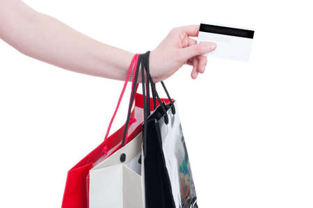 Woman hand holding credit card and gift bags as modern payment and shopping concept isolated on white backgroundの写真素材