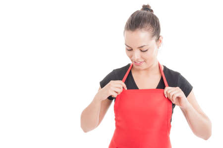 Joyful young supermarket saleswoman wearing apron and preparing for job isolated on white with text areaの写真素材