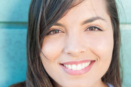 Close-up of young beautiful girl with natural look outside on green wall backgroundの写真素材