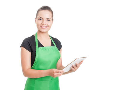 Successful hypermarket employee with green apron holding modern tablet isolated on white background with copyspaceの写真素材