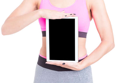 Woman holding black screen tablet wearing sports wear isolated on white background with copy text spaceの写真素材