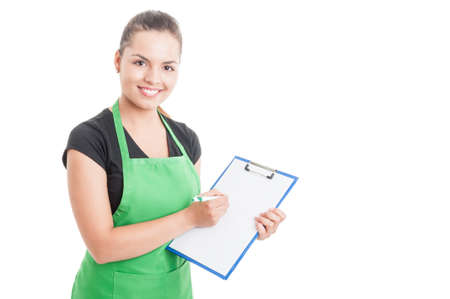 Attractive employee working in supermarket and holding clipboard while counting the stock isolated on white background with text areaの写真素材