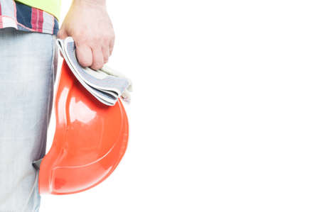 Closeup of safety helmet and gloves in male builder hand isolated on white background with copyspace