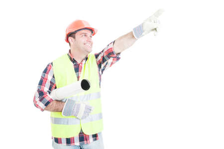 Happy architect with rolled building plan pointing finger at something isolated on white background