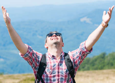 Backpacker feeling happy and victorious on top of the mountainの写真素材