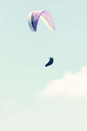 Paraglider in the sky in sun light and clouds with copy text spaceの写真素材