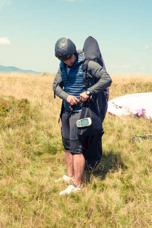 Male paraglider preparing his equipment for flying on a sunny dayの写真素材
