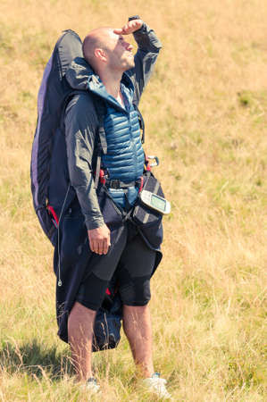 Paraglider looking up ready for the next flight in a summer sunny day wearing gliding equipmentの写真素材