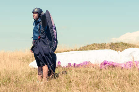 Male paraglider looking away waiting the perfect wind for taking offの写真素材