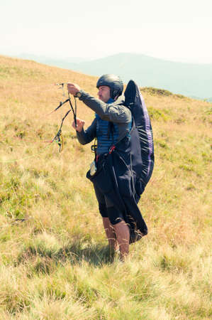 Paraglider preparing ropes for taking off in a summer sunny dayの写真素材