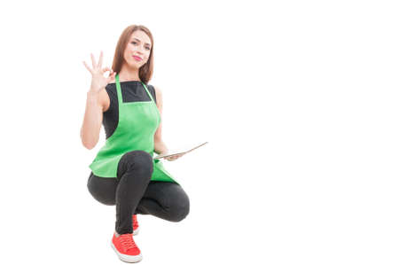 Young female seller doing ok sign as great stock results isolated on white with copyspaceの写真素材