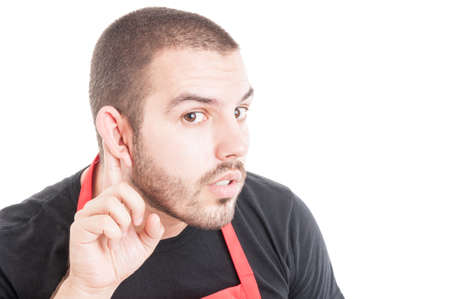 Attractive supermarket seller listening whispers and acting curious in closeup on white background
