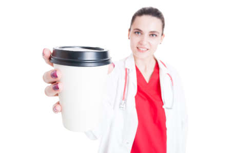 Attractive young medic offering coffee as break concept isolated on whiteの写真素材