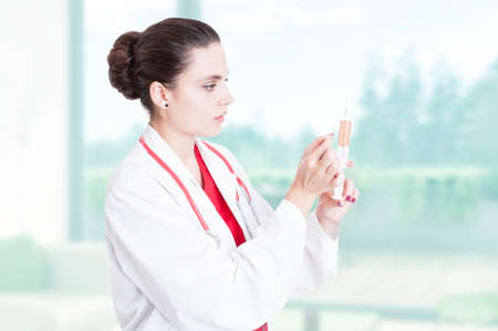 Woman doctor preparing medical syringe as treatment or vaccine conceptの写真素材