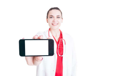 Cheerful medic holding mobilephone with blank screen and text space in closeup isolated on white backgroundの写真素材