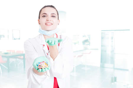 Cheerful pretty medic offering you capsules as illness cure concept with text areaの写真素材