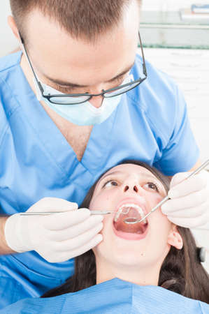Pretty girl sitting on dentist chair having a consult from doctor