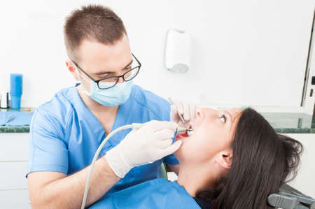 Girl sitting in dentist chair having a consultation from doctor with special toolsの写真素材