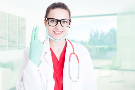 Gorgeous doctor showing two fingers as sexual connotation conceptの写真素材