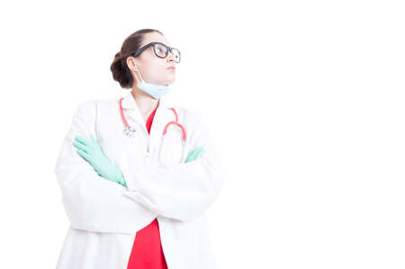 Low angle of woman medic with arms crossed looking up isolated on white backgroundの写真素材