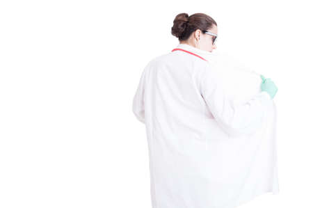 Pretty young medic holding her coat in back view isolated on white background with copy spaceの写真素材