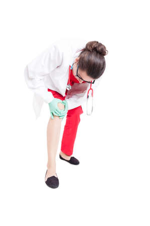 Medical assistant having injured knee as orthopedic problem concept isolated on white backgroundの写真素材