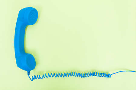 Retro telephone receiver with cord isolated on green background with copyspace as communication conceptの写真素材