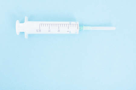 One syringe with needle on blue background with copy text areaの写真素材