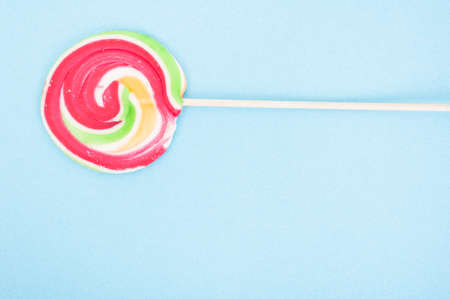 Closeup of swirl lollipop on blue background with text areaの写真素材