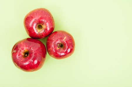 Top view of three tasty apples as fruit diet concept on green background with advertising areaの写真素材