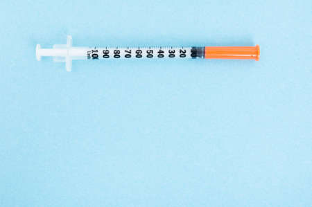 Plastic syringe for injection in close up isolated on blue with advertising areaの写真素材