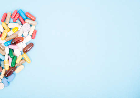 Pharmaceutical tablets and capsules on blue background side with copy space areaの写真素材