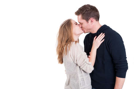 Handsome couple kissing and being affective wearing casual autumn clothes isolated on white...