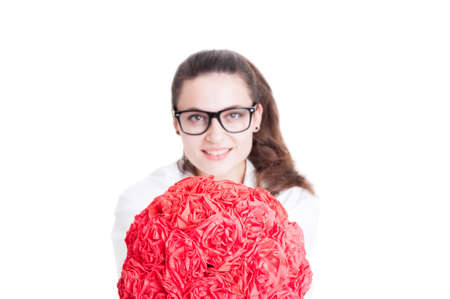 Joyful young woman doctor offering red paper roses on white background