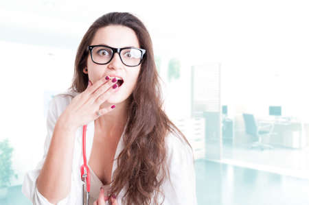 Attractive woman doctor with spectacles looking surprised or amazedの写真素材