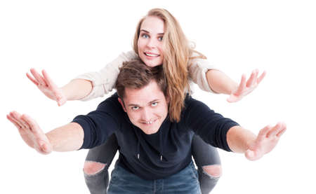 Handsome couple being playful posing as flying wearing autumn clothes isolated on white backgroundの写真素材