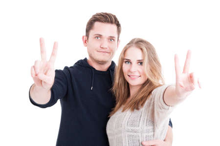 Happy handsome couple showing peace gesture wearing comfy autumn clothes isolated on white backgroundの写真素材