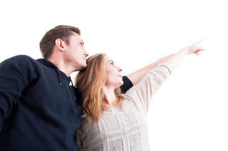 Low angle of couple pointing and wearing autumn clothes isolated on white backgroundの写真素材