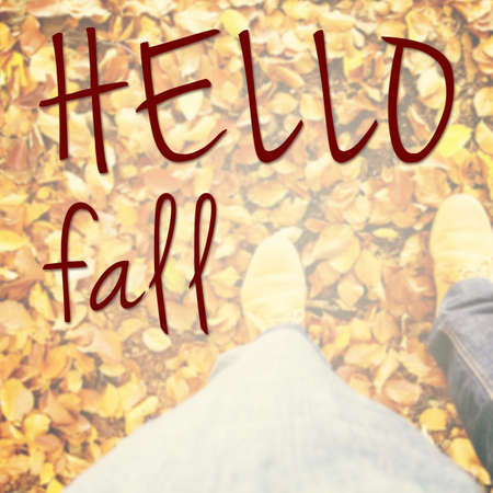 Hello fall inspirational message with person standing in the park on golden foliageの写真素材