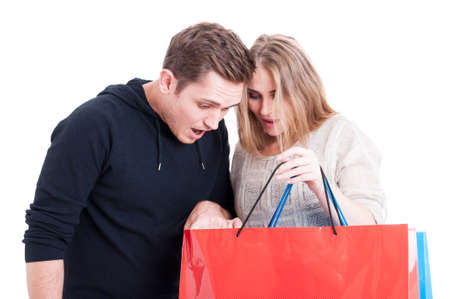 Couple looking in shopping bags and being surprised isolated on white backgroundの写真素材