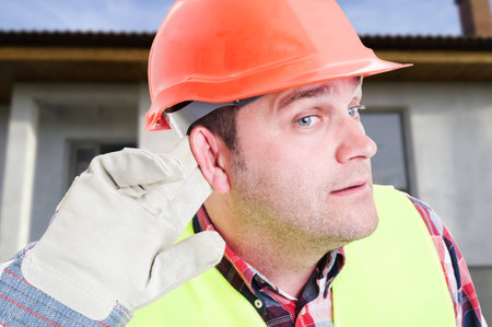 Curious engineer or builder listening the news outdoor on construction workplaceの写真素材