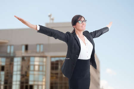 Joyful female realtor with arms outstretched celebrating victory or success at her jobの写真素材