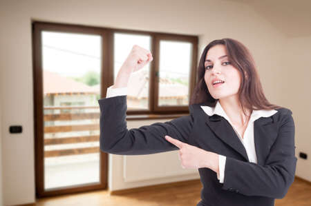Attractive female realtor showing her muscle as strength and confidence conceptの写真素材