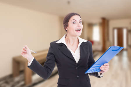 Smiling young realtor writing on clipboard as new rental contract conceptの写真素材